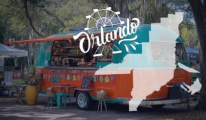 A vibrant food truck in Orlando with outdoor seating and decorations, surrounded by trees