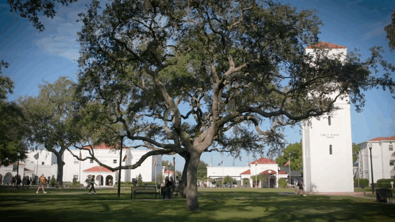 Montverde Academy campus with large oak trees, students walking, and the Carl E. Duncan Tower in view