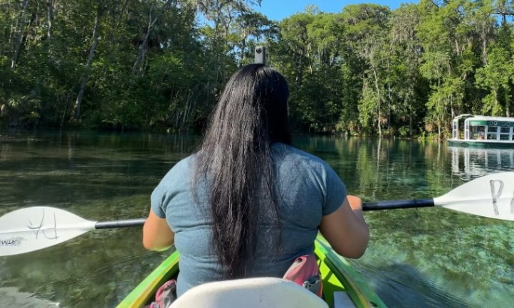 Kayaker paddling on crystal-clear spring water